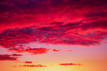 Evening sky with red and purple clouds, colored by the sunset rays.