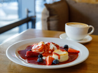 Cottage cheese pancakes. Russian syrniki with strawberry jam and sour cream on wooden table, selective focus. Traditional russian ukrainian breakfast in cafe, horizontal, copy space