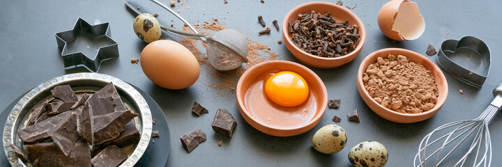 Mix of baking dessert ingredients on dark background, culinary flat lay