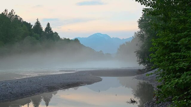 Beautiful Alpine river flowing in narrow valley. Mist over clean water. Pristine landscape in Slovenia. Static shot, real time, wide angle