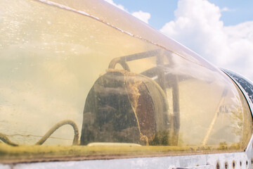 Close-up of a military fighter pilot's cockpit. A crack is visible on the glass, which has turned yellow with age. Decommissioned military equipment. Airplane pilot seat