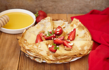 Pancakes, thin pancakes with fresh strawberries. On the background. View from above. Copy space.