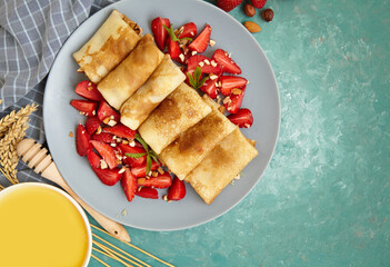 Pancakes, thin pancakes with fresh strawberries. On the background. View from above. Copy space.