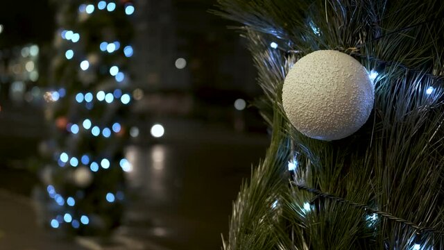 Pine instalation in the city. A view of a pine installation with Christmas balls and garlands in the night.