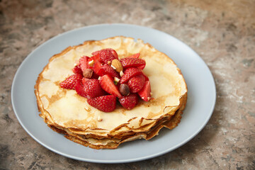 Pancakes, thin pancakes with fresh strawberries. On an empty background. Copy space.