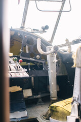 A close up of the cockpit of a vintage airplane. The steering wheel, dashboard, seat and climb levers are visible. Decommissioned aircraft. Everything is broken and damaged from time to time.