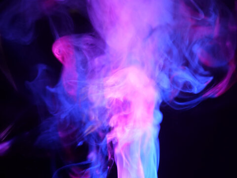 Abstract color series. Composition of colorful smoke in motion. Fusion of purple and blue mist isolated on a dark background to inspire creativity.