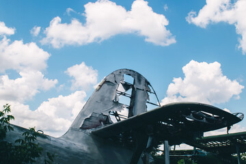 The tail of an aircraft that has collapsed from time to time or from an accident. Metal parts of the frame, parts of the fuselage, skin and pieces of fabric are visible. Rust and scraps of old fabric