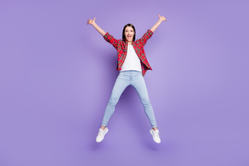 Full body photo of active brunette hairdo millennial lady jump wear red shirt jeans isolated on purple color background