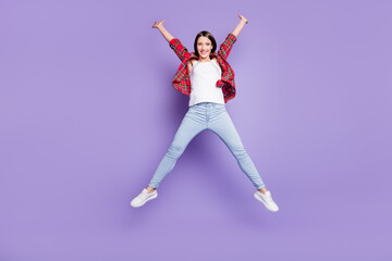 Fototapeta premium Full size photo of cool brunette hairdo young lady jump wear red shirt jeans isolated on purple color background