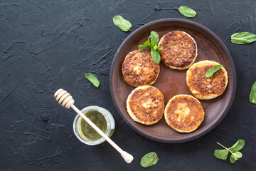 A healthy breakfast of cheese pancakes and honey. Creative atmospheric decoration