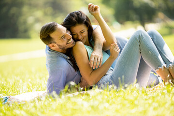 Affectionate young couple sitting on the green grass