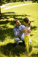 Fototapeta premium Father with daughter having fun on the grass at the park