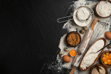 Obraz na płótnie Canvas Baking ingredients for dough on black background