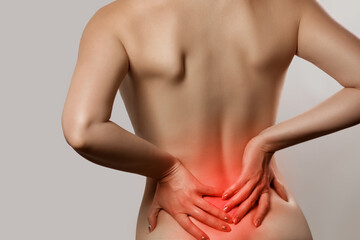 Woman having backache, pain back isolated on gray background. Scoliosis. Spinal cord problems on...