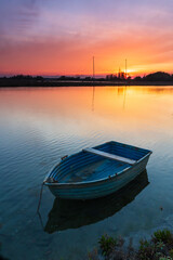 Fototapeta na wymiar Vista con una barca in primo piano e con il tramonto dietro a Marina Romea in Italia. Vacanze. Gita sul mare. Viaggiare.