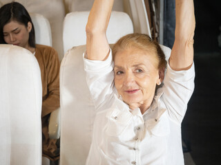 tired and relaxed, sleepy and yawning for early morning, An elderly female passenger stretched fatigue on a passenger plane.