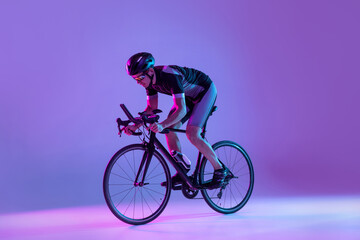 Cyclist riding a bicycle isolated against neon background
