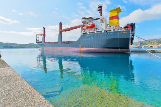 Greece siros island, cargo ship on green still water