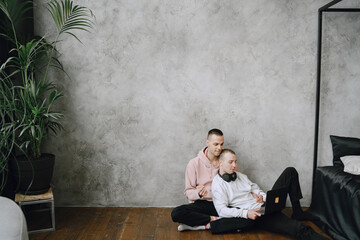 Gay couple consulting their travel plans together with a laptop