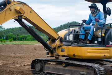 mini excavator digging soil with mountain background
