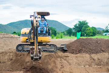 mini excavator digging soil with mountain background