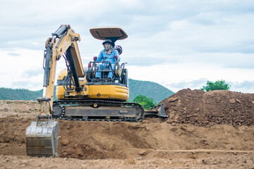 mini excavator digging soil with mountain background
