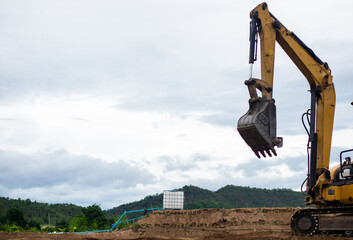 A mini excavator is digging the soil in the field.