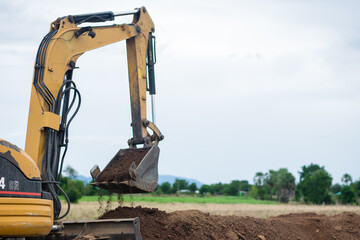 mini excavator digging soil with mountain background