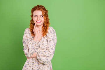 Photo of cheerful young happy nice lady look empty space think smile isolated on green color...