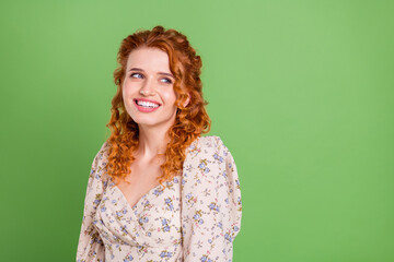Obraz premium Photo of charming positive nice lady look empty space dream nice smile isolated on green color background