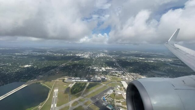 View through airplane window as the plane descends and lands at Orlando International Airport.