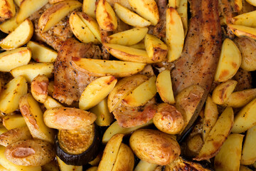 Baked potatoes with cheese, meat, bacon, mushrooms, turmeric and other spices from the oven close-up, concept food at home