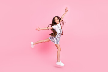 Full body photo of cheerful positive happy nice small girl good mood jump up isolated on pink color background