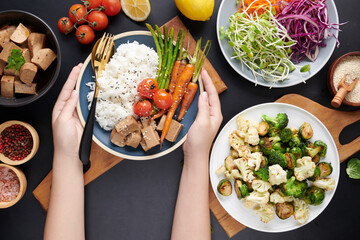 Top view of female hands holding bowl with mixed vegetables salad, young woman eating fresh salad meal vegetarian. healthy organic tofu and rice buddha bowl with veggies. Clean detox healthy food.