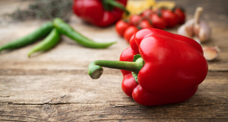 red pepper and various vegetables on wooden background