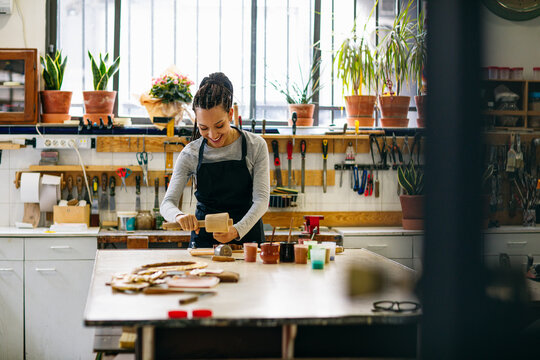 Positive female artisan restoring wooden piece 