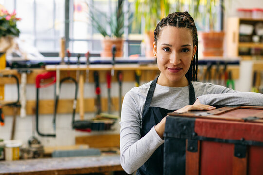 Smiling craftswoman in woodwork studio 