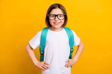 Photo portrait small schoolgirl smiling staring amazed blue rucksack isolated bright yellow color background