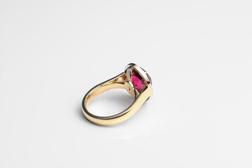 Beautiful expensive gold ring with rhodolite and diamonds on a white background. Reverse side