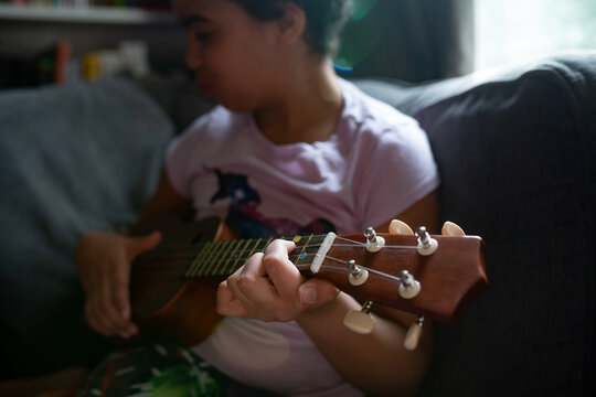 closeup of girl playing chords on ukelele