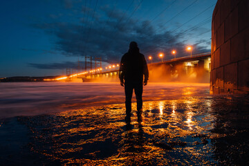 translucent Man's silhouette by a dam