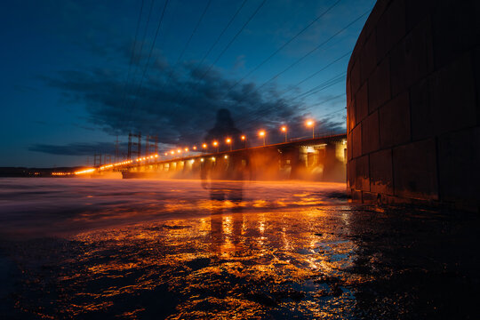 translucent Man's silhouette by a dam