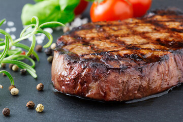 grilled steak with vegetables on slate background
