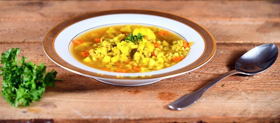 Vegetable soup on a plate on the wooden table