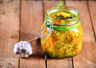 Vegetable soup in the jar on the wooden table