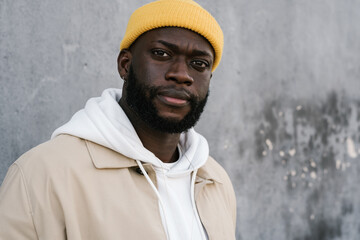 Back man with a cap facing the camera with a serious look