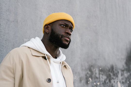 Portrait of a back man with a cap and a serious look.