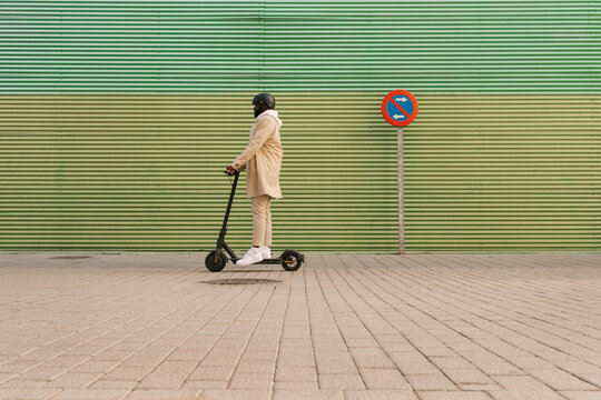 Black man with helmet on an electric scooter