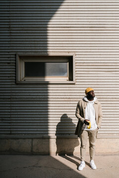 Black man standing outdoors with sunlight on him.